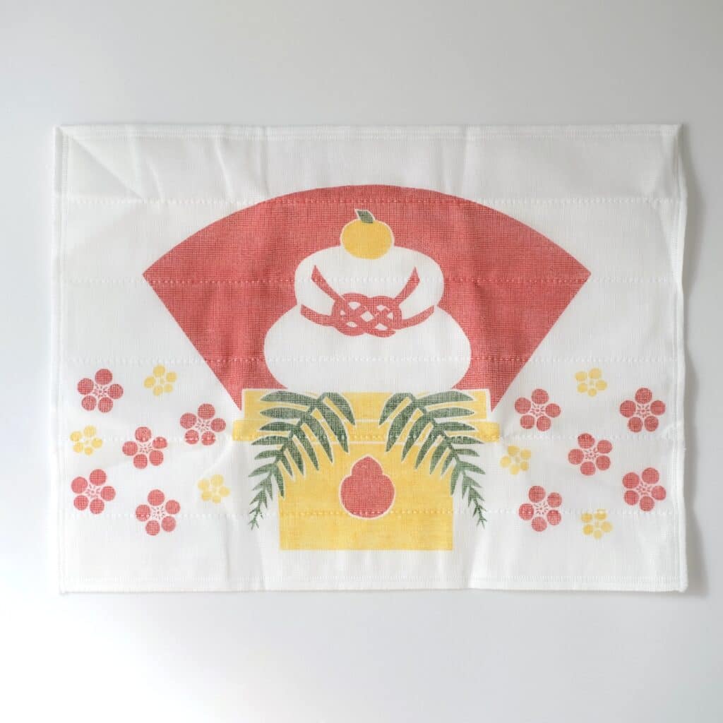 鏡餅のうしろに扇型が、周りには梅が散りばめられた遊び心のあるデザインです。